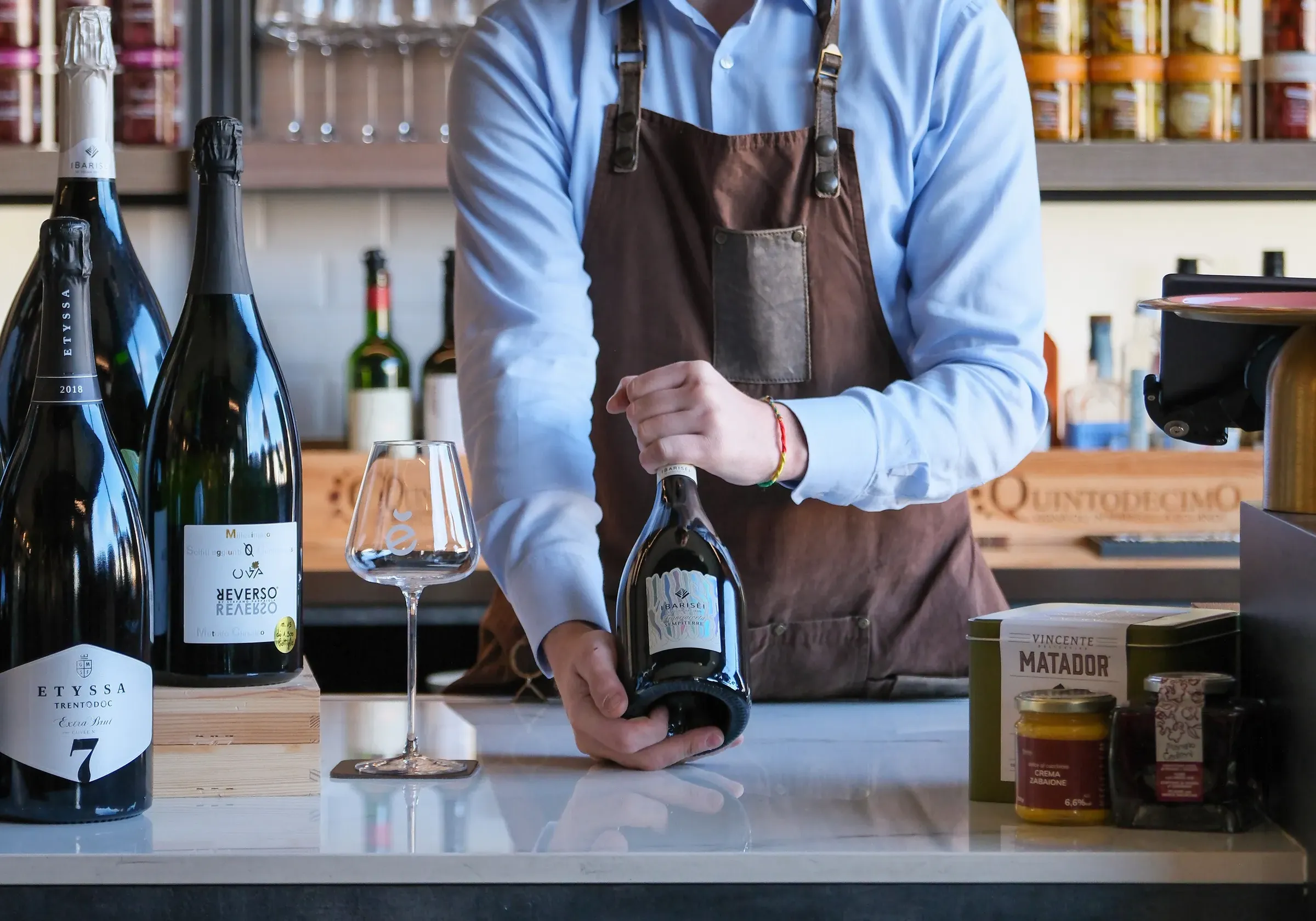 Sommelier ENOè a Vicenza che presenta una bottiglia di vino
